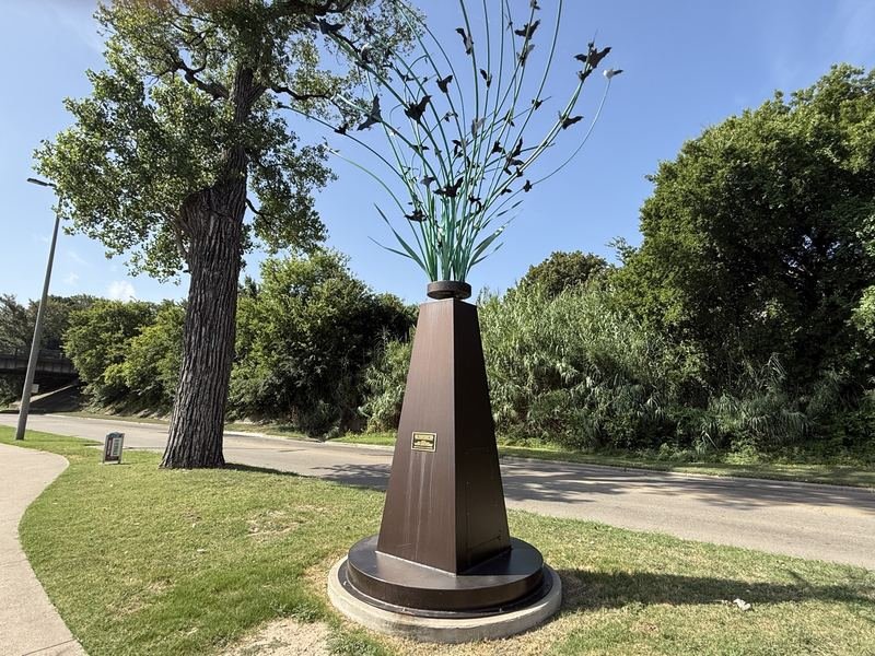Aluminum bat sculptures bursting into flight along the Waco riverwalk