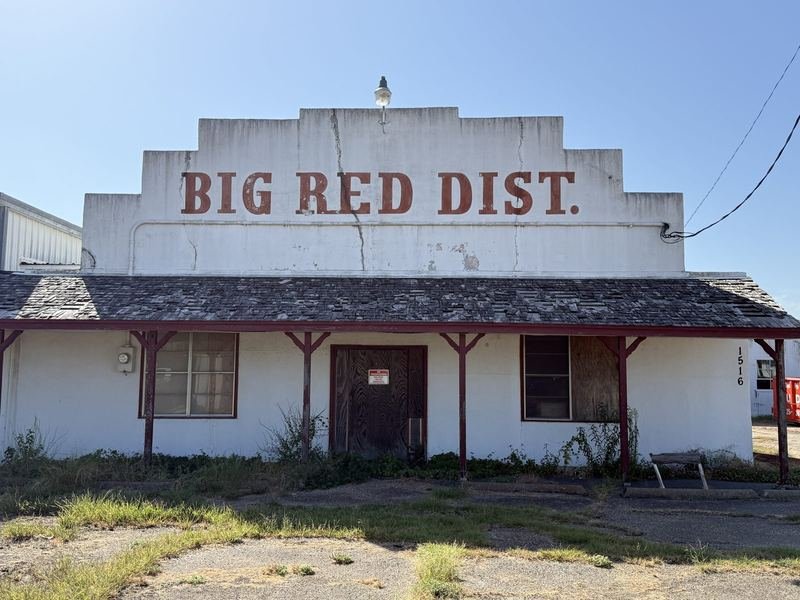 The faded BIG RED DIST. ghost sign on the stepped parapet of the old distribution building at 1516 La Salle Avenue, Waco