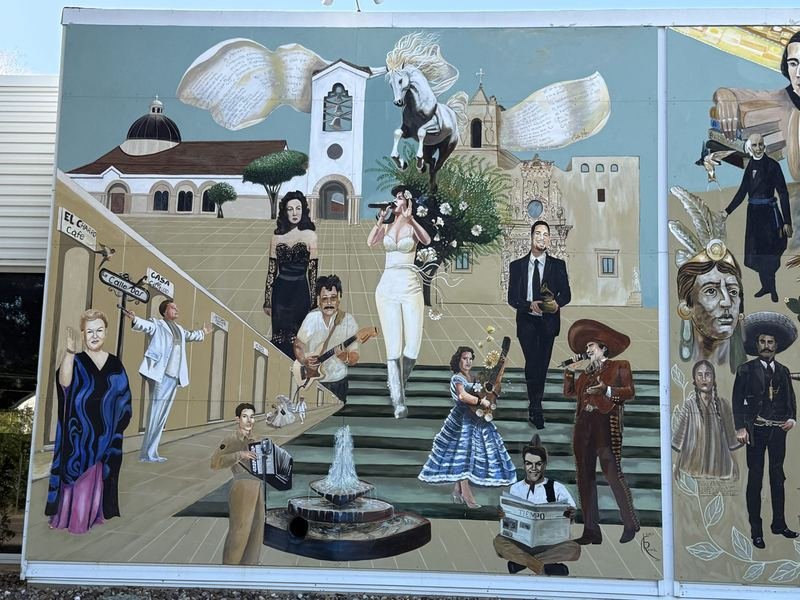 The Calle Dos panel of La Dignidad showing the plaza, fountain, musicians, dancers and a mariachi in full regalia