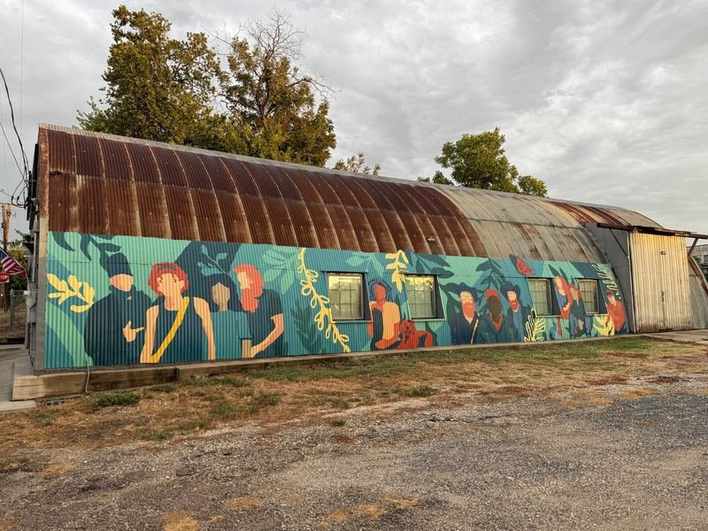 The Crowd at the Hangar — The whole hut from the gravel lot