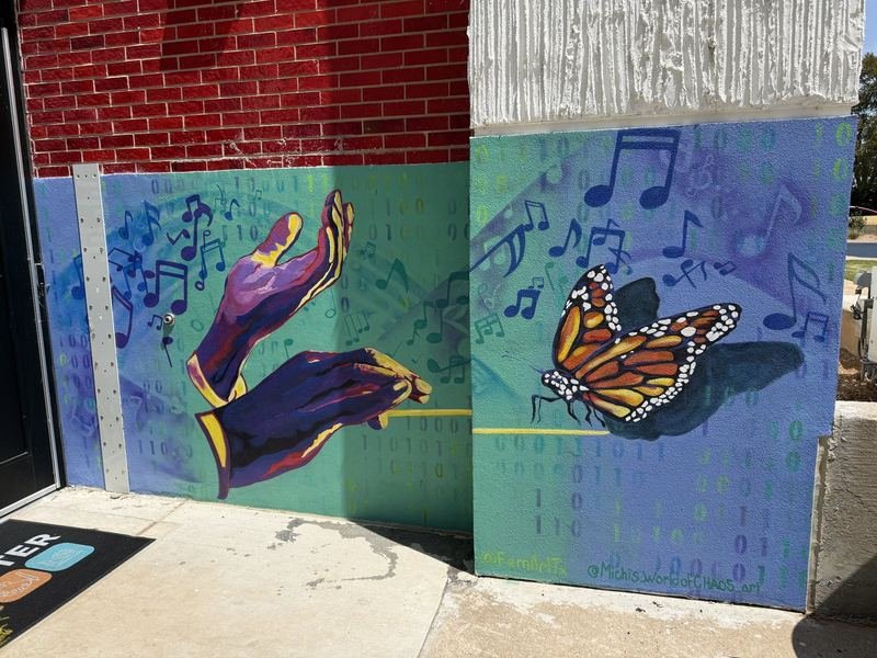 The Building With a Spacecraft in the Lobby — Hands conducting, and a monarch on the baton